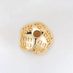 Detail of 14k gold plated copper flower spacer bead with grid texture and central hole