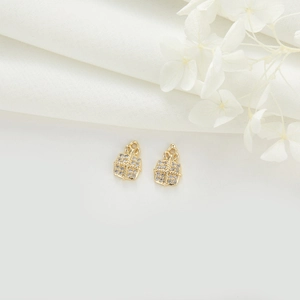 Détails de deux pendentifs boîte cadeau dorés avec zircons blancs et nœuds élégants