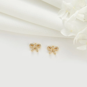 Detail showing 14k gold-plated bow charm with sparkling white zircons for DIY jewelry