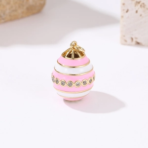 Macro shot of 14k gold Fabergé style egg pendant with pink enamel and pavé zircon details