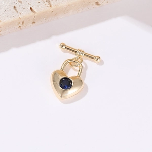 Détail d'un médaillon cœur en or 14 carats avec pierre bleue et fermoir à bascule en T