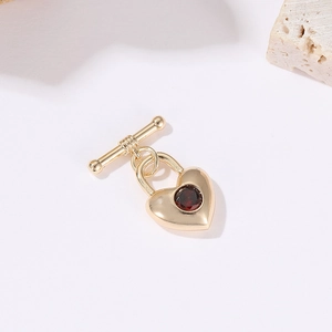 Détail d'un fermoir à bascule en forme de cœur plaqué or 14 carats avec zircon rouge