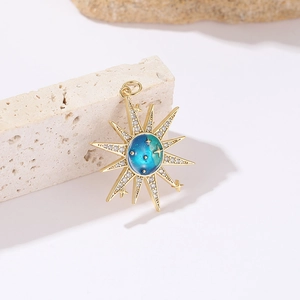 Golden sunburst star pendant with blue enamel galaxy center and white zircon stones