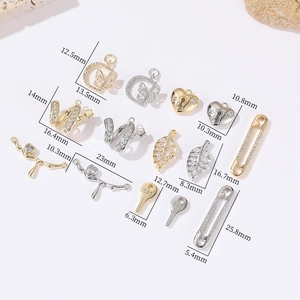 Makro-Detail von DIY-Schmuckanhängern in Gold und Silber mit 520 Schlüssel- und Herzmotiven