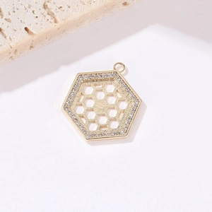 Macro shot of a 14k gold plated hexagonal honeycomb pendant with sparkling zircon accents