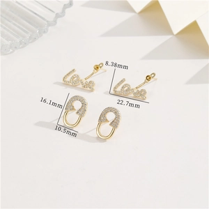 Detail of gold Love stud and safety pin earrings with cubic zirconia pavé stones