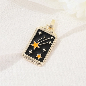 Detailed macro of 14K gold-plated tarot 'The Star' pendant with black enamel finish