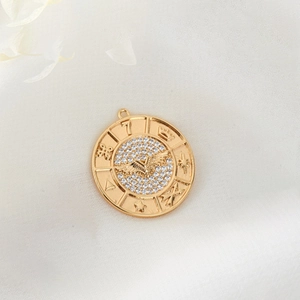Macro shot of 14K gold plated eagle coin pendant with sparkling white zircons and relief