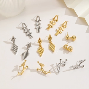 Minimalistische geometrische Ohrringe in Gold und Silber auf schickem beigem Hintergrund