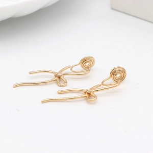 Detailed view of elegant gold bow-shaped clip-on earrings with secure spiral mechanism