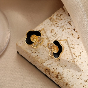 Elegante bloemknop oorbellen van goud metaal met zwart emaille en fonkelende zirkoonaccenten