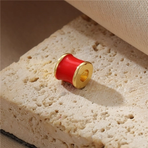 Macro-opname van een 14K vergulde rode emaille kraal voor DIY-sieraden en armbanden