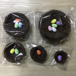 Detailed top view of handmade rattan bird nests with colorful speckled Easter eggs