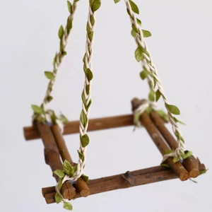 Natural wood parrot swing with hemp rope and green leaves for bird climbing and playing