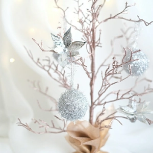 Sparkly silver Christmas ball ornaments and glitter flowers on a festive holiday tree