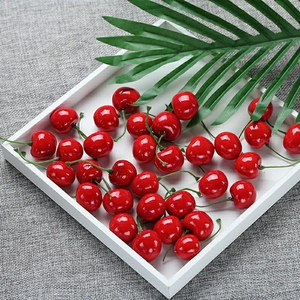 Realistic artificial red cherries in white tray for photography and home decor