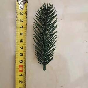 Detail view of 11.5cm artificial pine needle branch with measuring tape for size