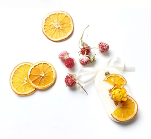 Handmade aroma wax tablet with dried orange and yellow flower on white ribbon