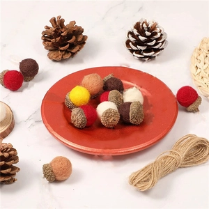 Close-up of colorful wool felt acorns in a red ceramic bowl for festive holiday decoration