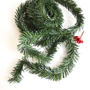 Artificial green pine needle garland with red berries for Christmas decoration