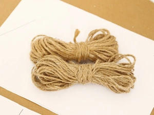 Two rolls of natural jute twine on a white card for DIY crafts and gift packaging
