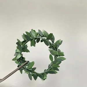Miniature artificial green leaf wreath with textured foliage for DIY crafting projects