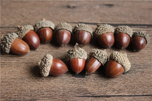 Natural dried acorns with caps for Christmas DIY crafts on a rustic wooden background