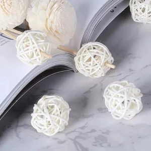 Boules de rotin blanc 3cm avec bâtonnets diffuseurs et fleurs sur marbre blanc