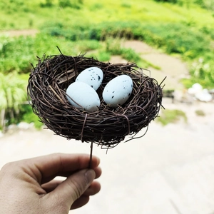 Artificial bird nest with three blue spotted eggs on a stem for Easter floral decoration