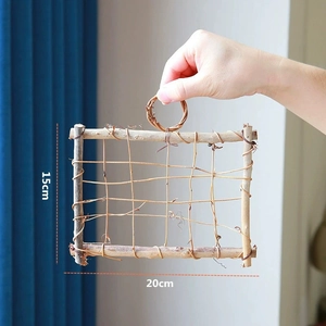 Handheld view of a 20x15cm natural woven wood branch frame with top handle loop