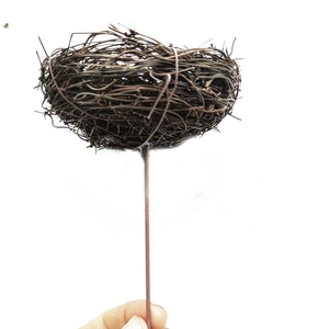 Artficial bird nest on a stick made of woven rattan for Easter decor and floral arrangements