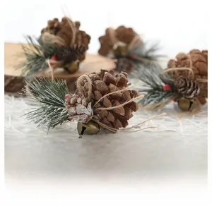 Close-up of pine cone Christmas ornament with faux needles, red berries and a vintage bell