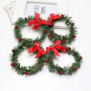 Lot de quatre mini couronnes de Noël avec aiguilles de pin, baies rouges et nœuds