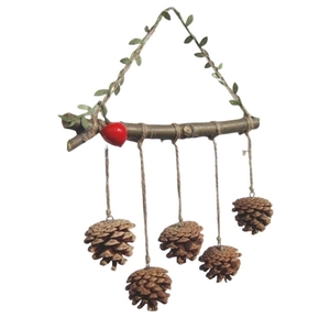Detail of pine cone wall hanging with rustic wood, red berry and green leaf elements