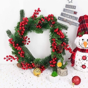 Christmas wreath with red holly berries, pine cones and gold ball for door decor