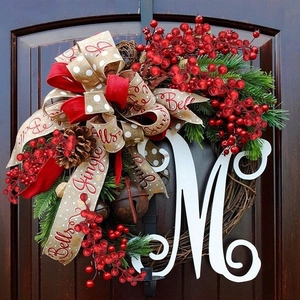 Christmas holly berry wreath with white letter M, pine cones and rustic jingle bells