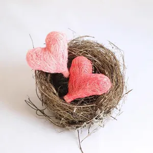 Macro-opname van handgemaakte roze gevlochten strooien hartjes in een rustiek nest