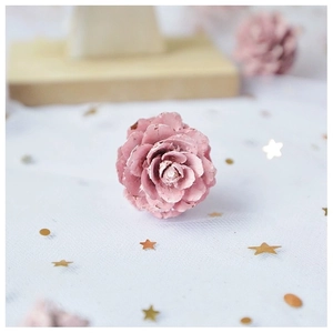 Vue détaillée d'une rose artisanale en pomme de pin rose pour décoration de Noël