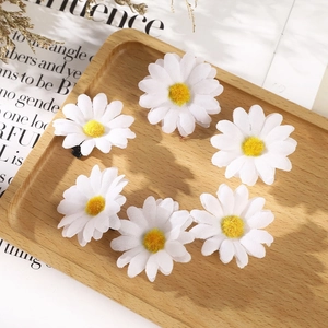 Set of 6 white fabric daisy hair clips with yellow center on a wooden tray