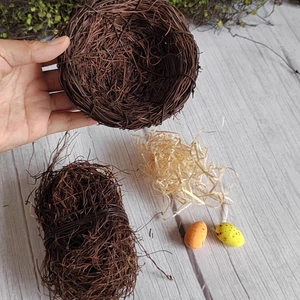 Handmade rattan bird nest with colorful decorative eggs and filler for garden decoration