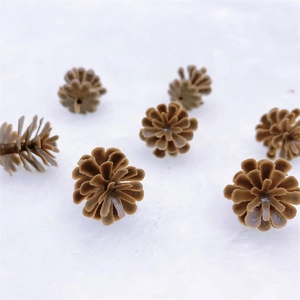 Realistic brown plastic pine cones for Christmas decoration and DIY crafts on white plush