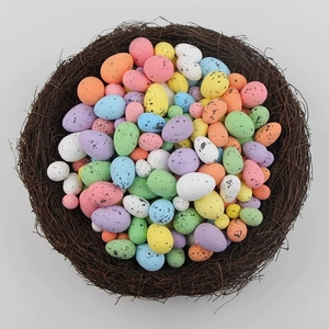 Close-up of colorful speckled Easter eggs in a realistic woven rattan bird nest decor