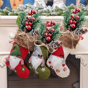 Three Christmas stockings with gnomes, pine needles, and red berries on a fireplace