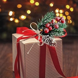 Christmas gift box with pine needles red berries and pine cones on a dark wood background