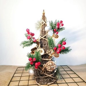 Detail of cone-shaped Christmas tree decoration with pine needles and red berries