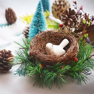Christmas pine needle wreath with a white ceramic bird and natural woven nest base