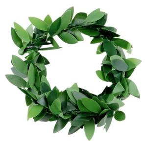 Détail d'un rond de serviette avec feuilles vertes artificielles pour décor festif
