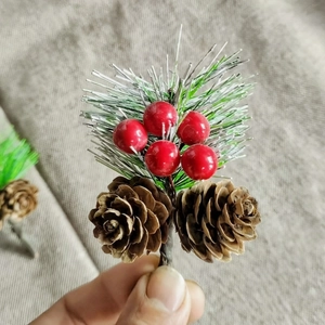 Miniature Christmas pick with pine cones, red berries and green pine needles on a stem