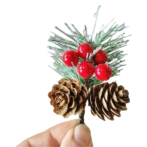 Close-up of frosted pine needles with red berries and natural pine cones for Christmas