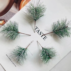 Detail of five artificial pine needles with faux snow coating for Christmas DIY decor